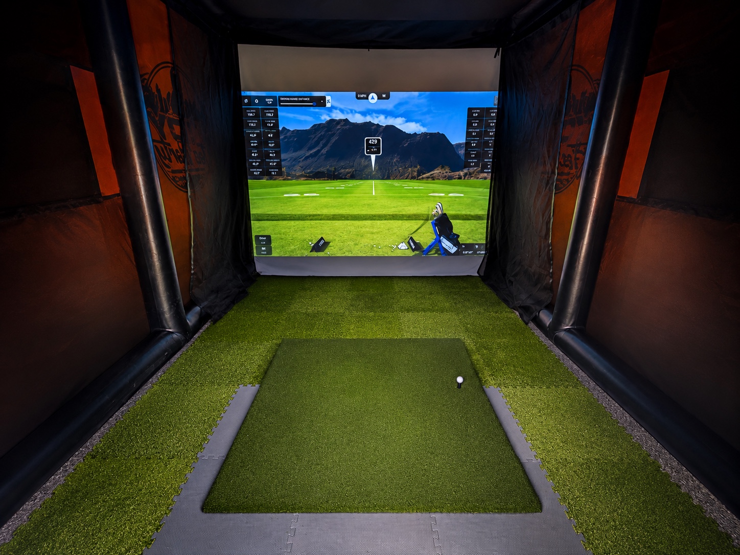 Indy Tee Party simulator with the golf screen on and the hitting area ready